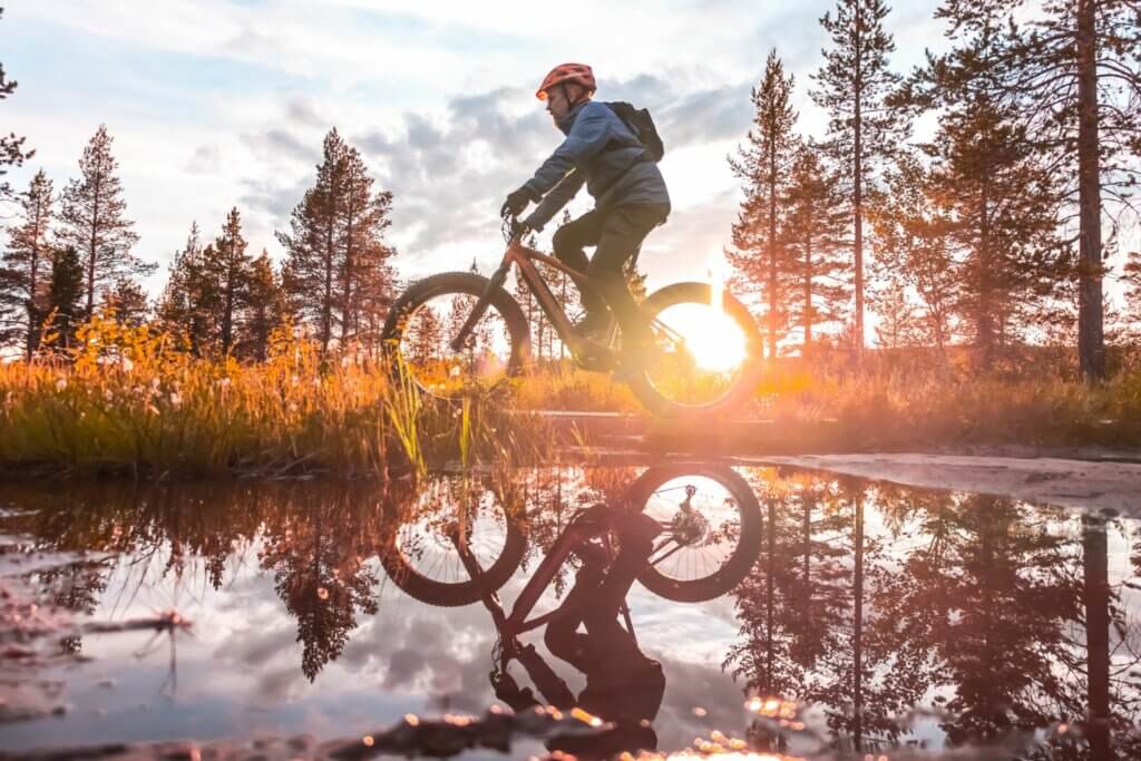 Maastopyöräilijä ilta-auringossa Saariselän reiteillä.