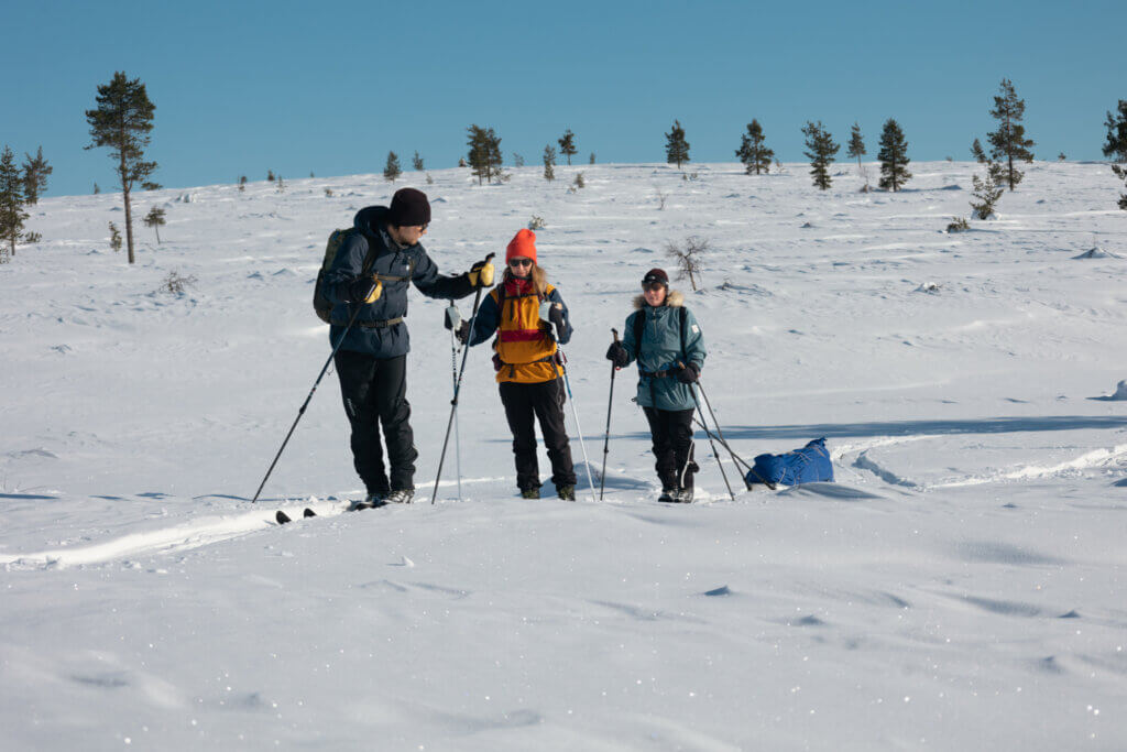 Keväthangilla hiihtäjiä tunturimaisemassa.