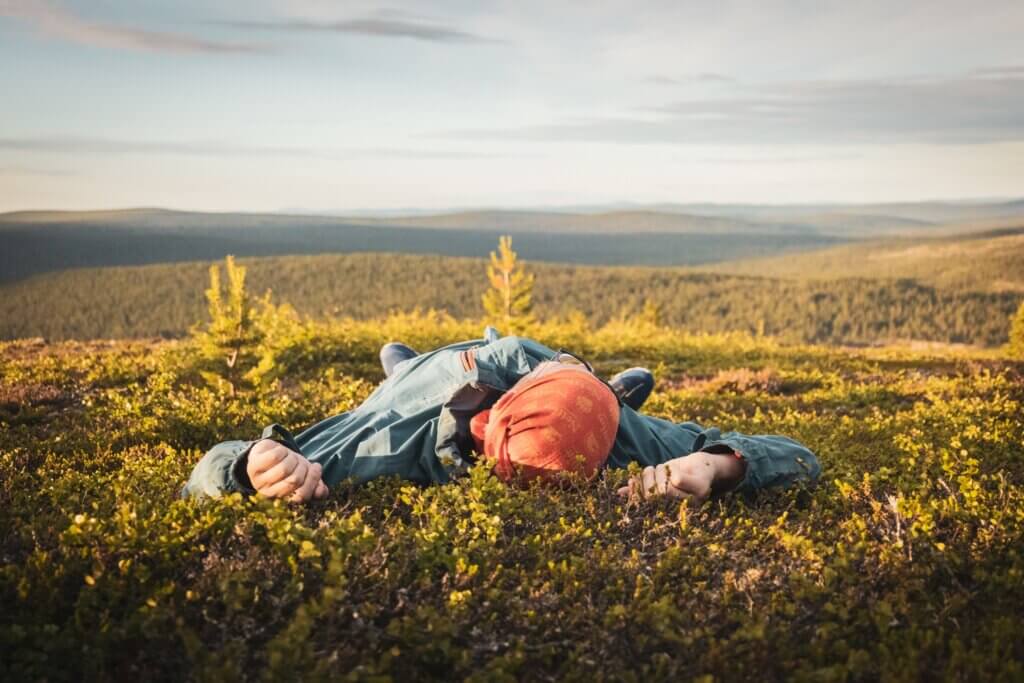 Kiilopään tunturimaisemassa ihminen makoilemassa varpujen seassa.