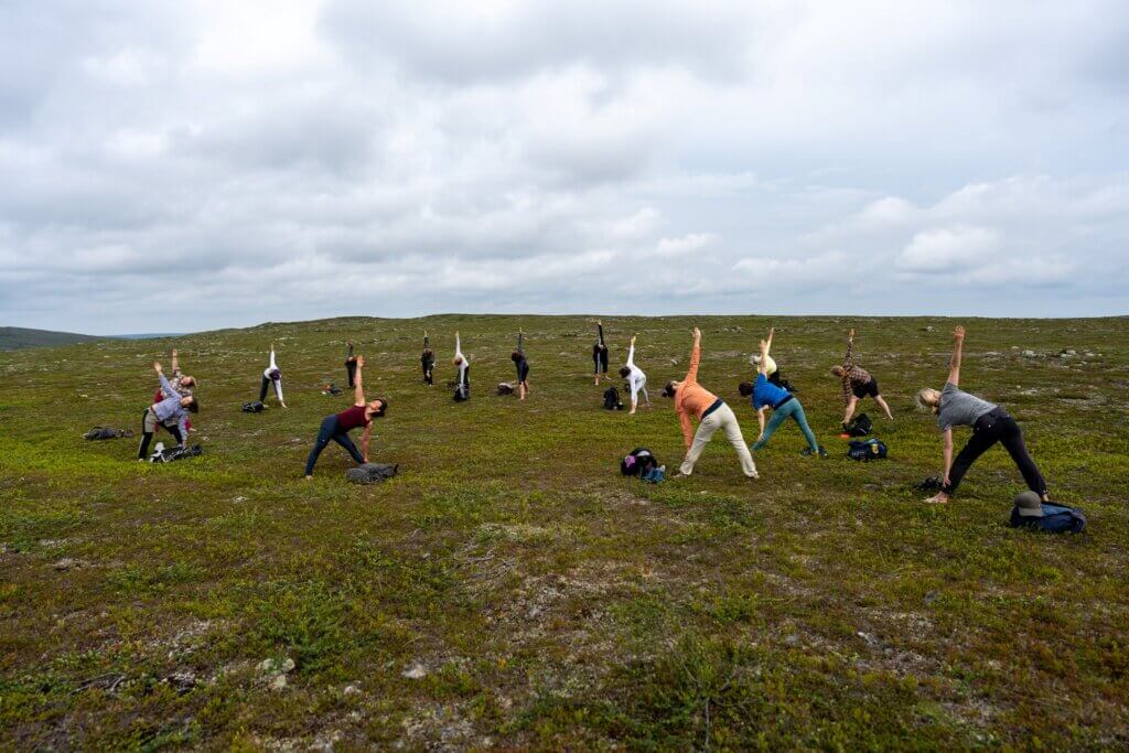 Ryhmä joogaa kesäisessä tunturimaisemassa.