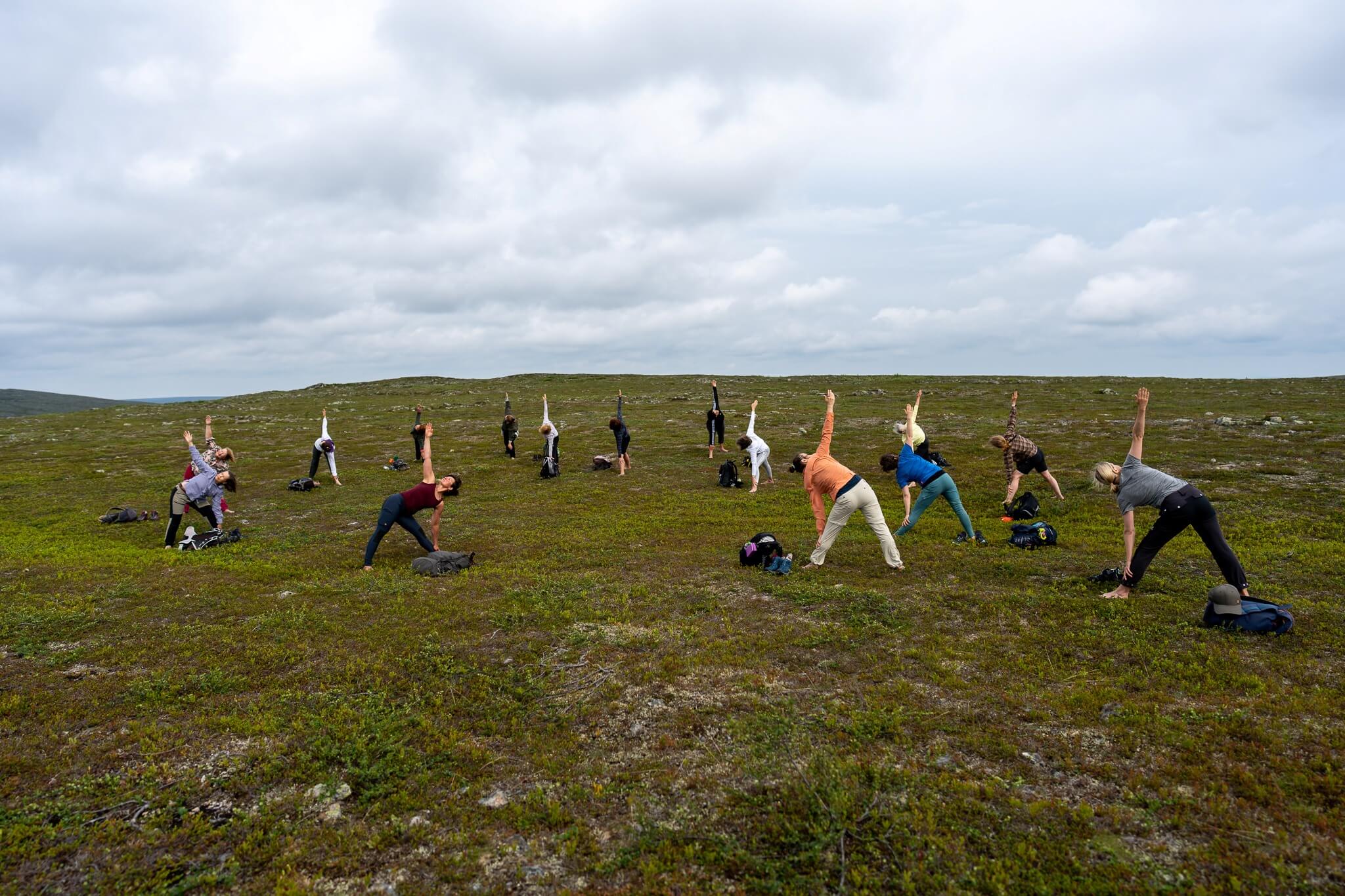 Ryhmä joogaa kesäisessä tunturimaisemassa.