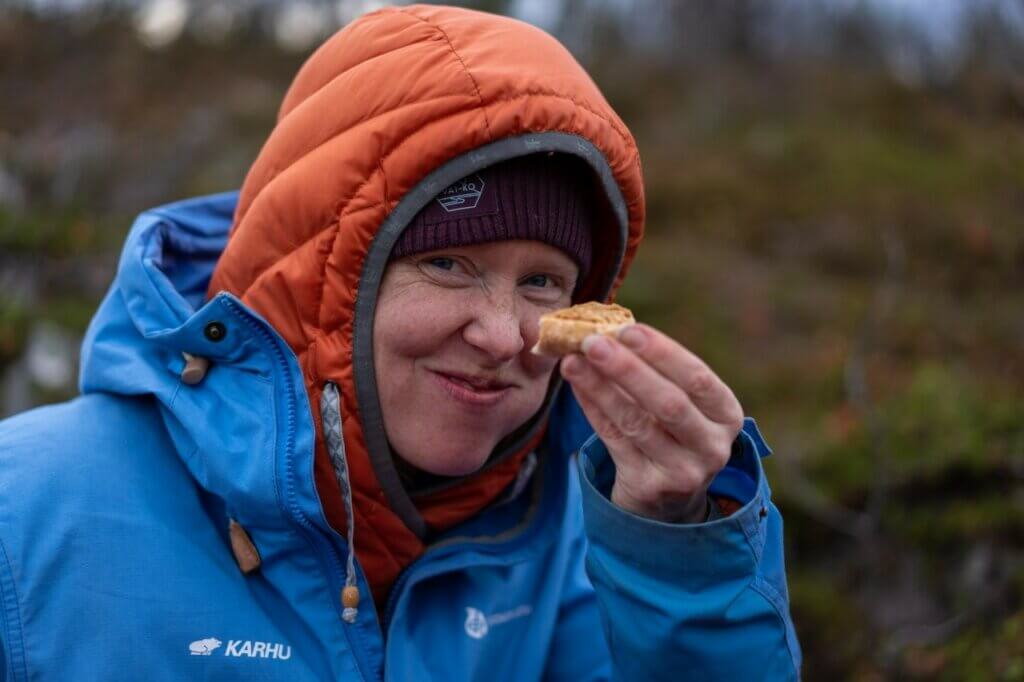 Nainen vaelluksella, tauoalla, nauttii eväitä