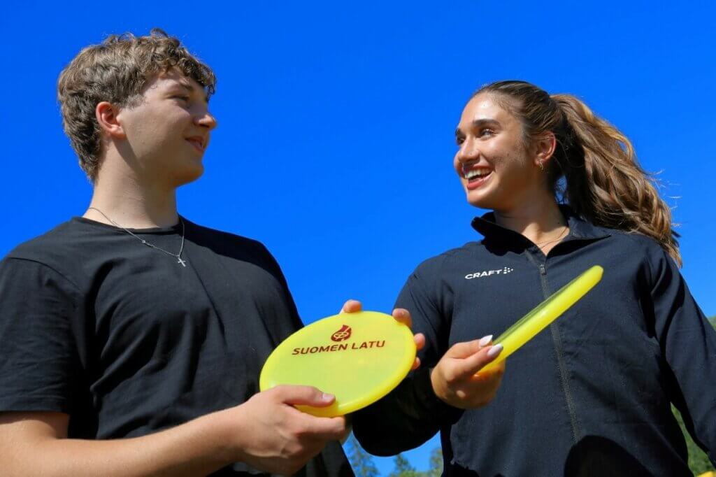 Nuori pariskunta pelaa frisbeegolfia.